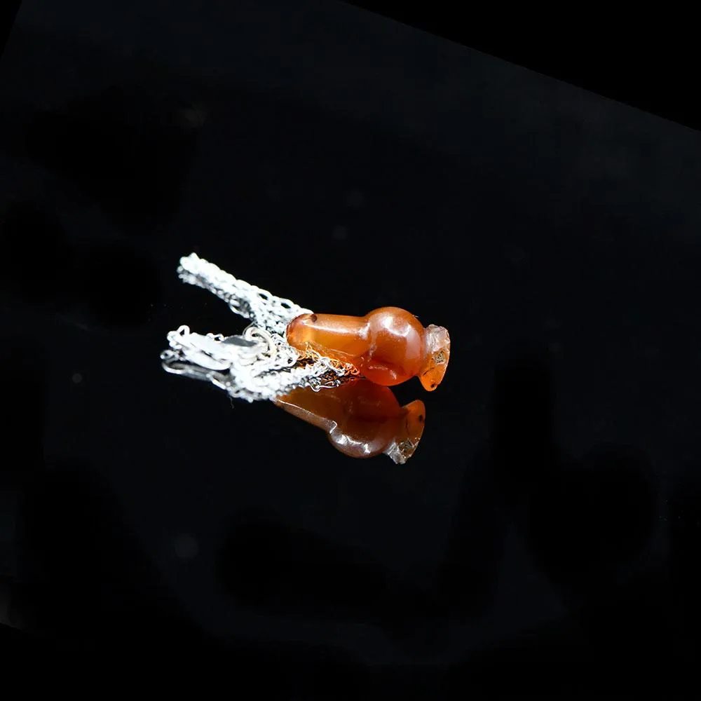 An Egyptian Carnelian Poppy Bead Pendant, New Kingdom, 18th - 19th Dynasty, ca. 1550 - 1295 BCE