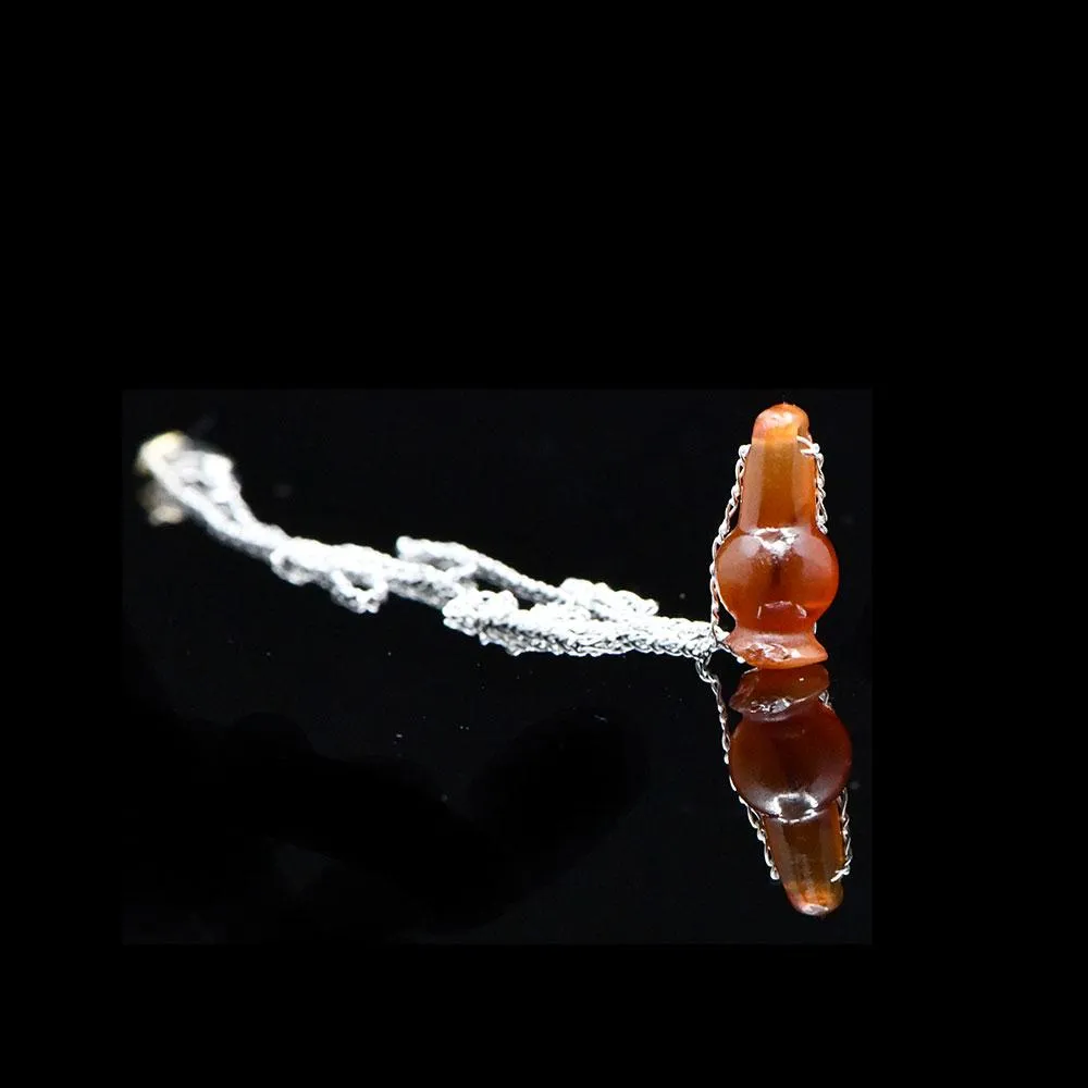 An Egyptian Carnelian Poppy Bead Pendant, New Kingdom, 18th - 19th Dynasty, ca. 1550 - 1295 BCE